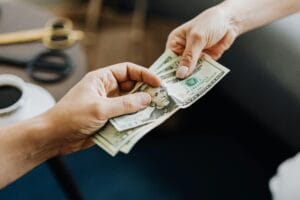 Hands exchanging cash during a payment or financial transaction