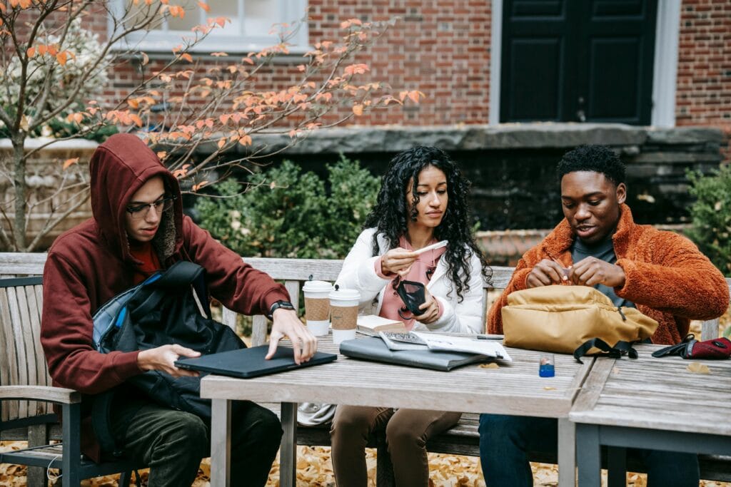 Diverse students with backpacks sitting at the table